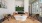 a seating area with a white coffee table, chairs on each side and a tan couch
