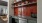 a sink area with a red backsplash and shelves