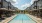swimming pool in a courtyard with lounge chairs and umbrellas
