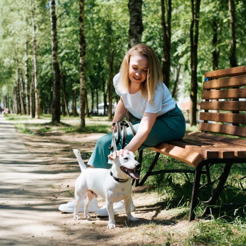 a woman and her dog at a bench outside